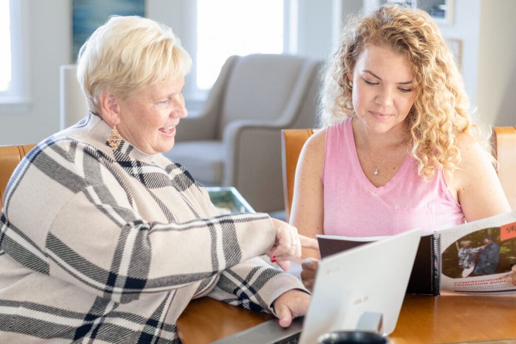 Two women look at a workbook